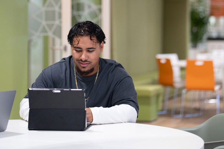 Associate degree student achter zijn laptop