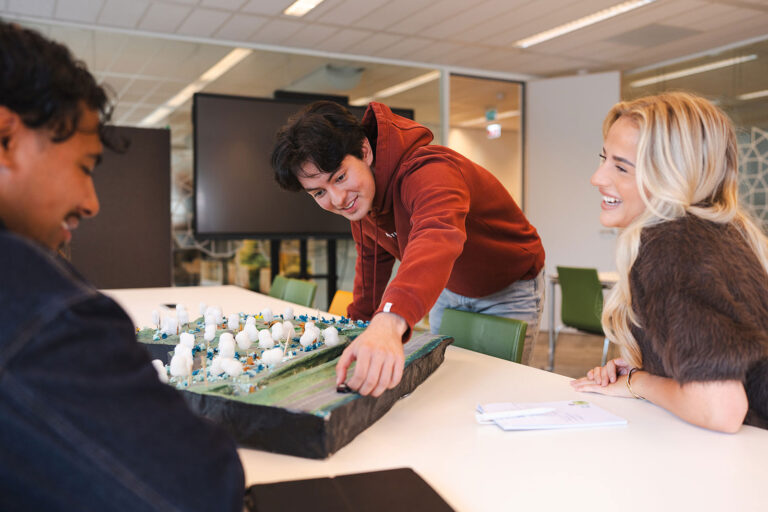 drie Associate degree studenten werken samen aan een project van de opleiding