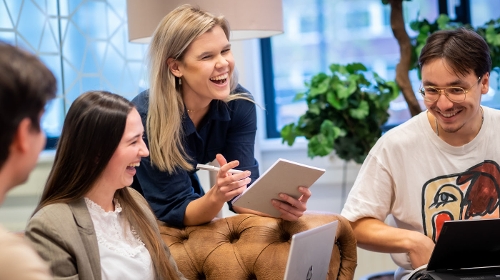 Vier lachende studenten die gezellig samenwerken bij Associate degrees Academie in Roosendaal
